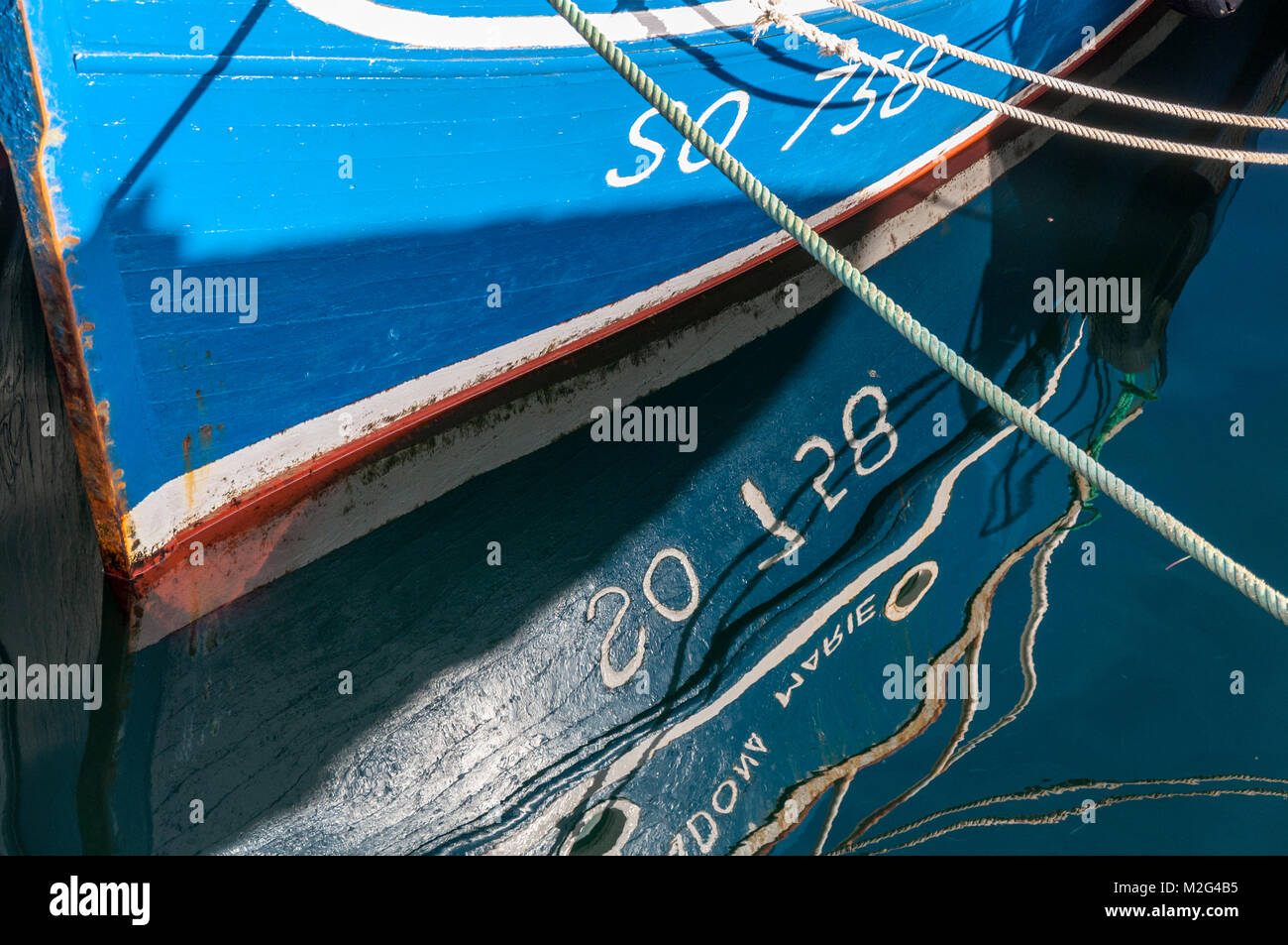 In legno barca da pesca e di riflessione in acqua, Burtonport, County Donegal, Irlanda Foto Stock