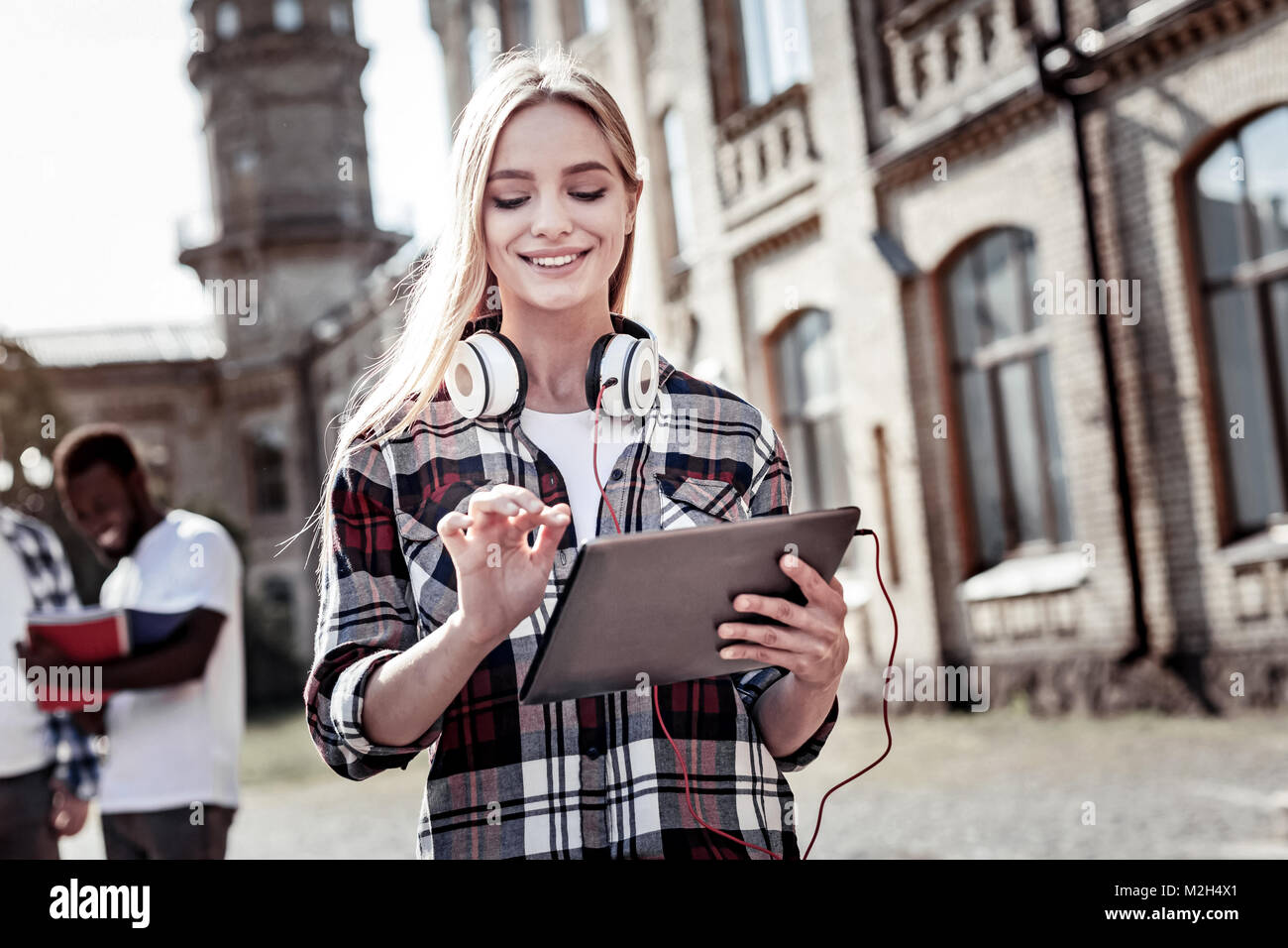 Gioiosa bella donna tenendo un tablet Foto Stock