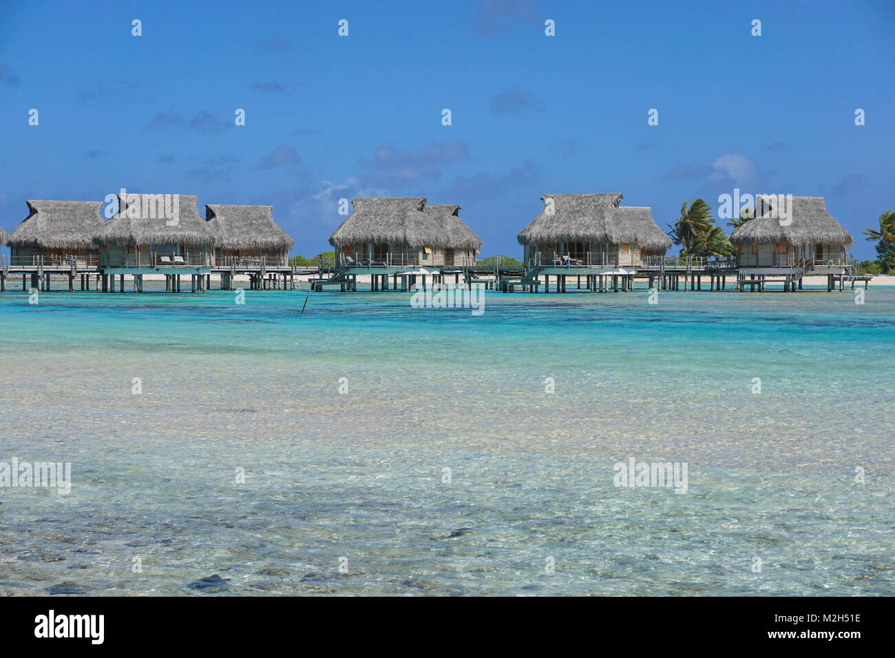 Resort tropicale con bungalow Overwater in laguna, Tikehau Atoll, Tuamotus, Polinesia francese, oceano pacifico, Oceania Foto Stock