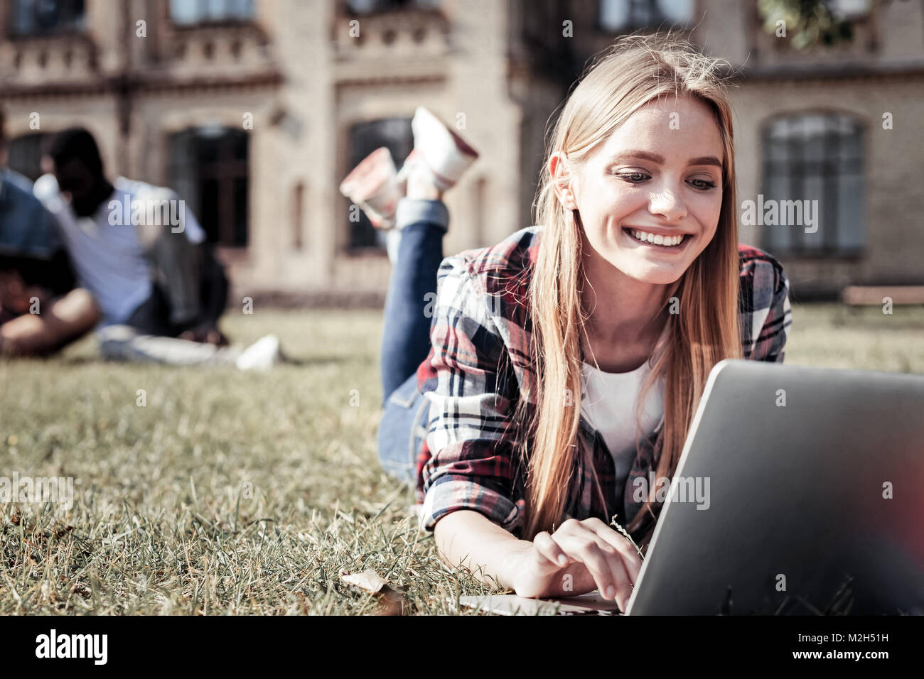 Felice giovane donna sdraiati sull'erba Foto Stock