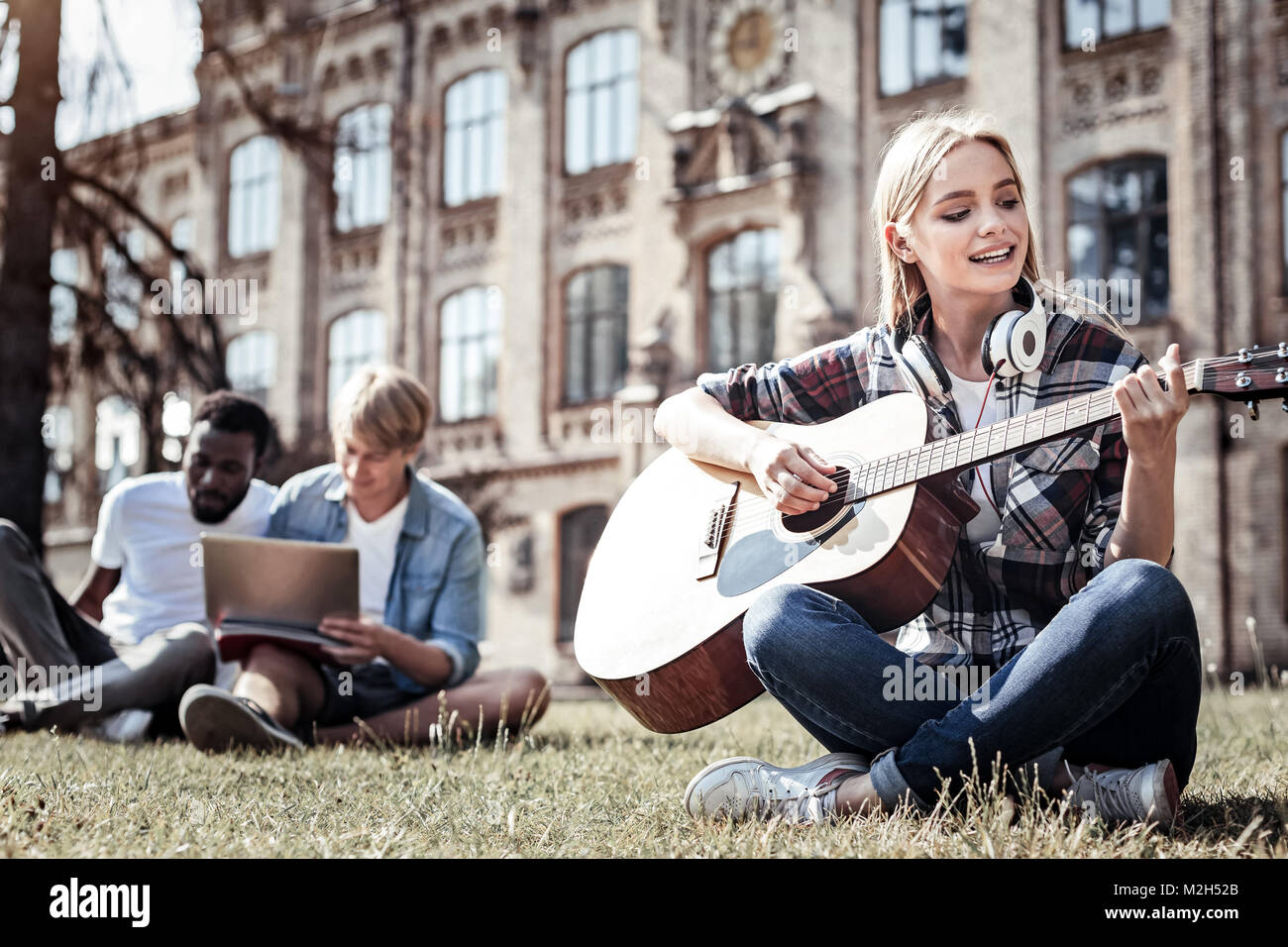 Gioiosa donna di talento di suonare una chitarra Foto Stock