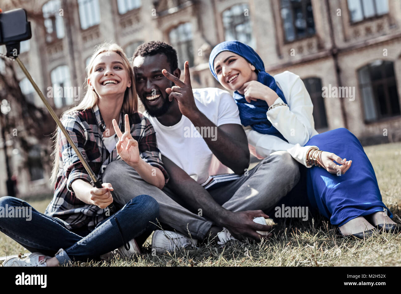 Allegro studente emotivo che mostra V segno Foto Stock