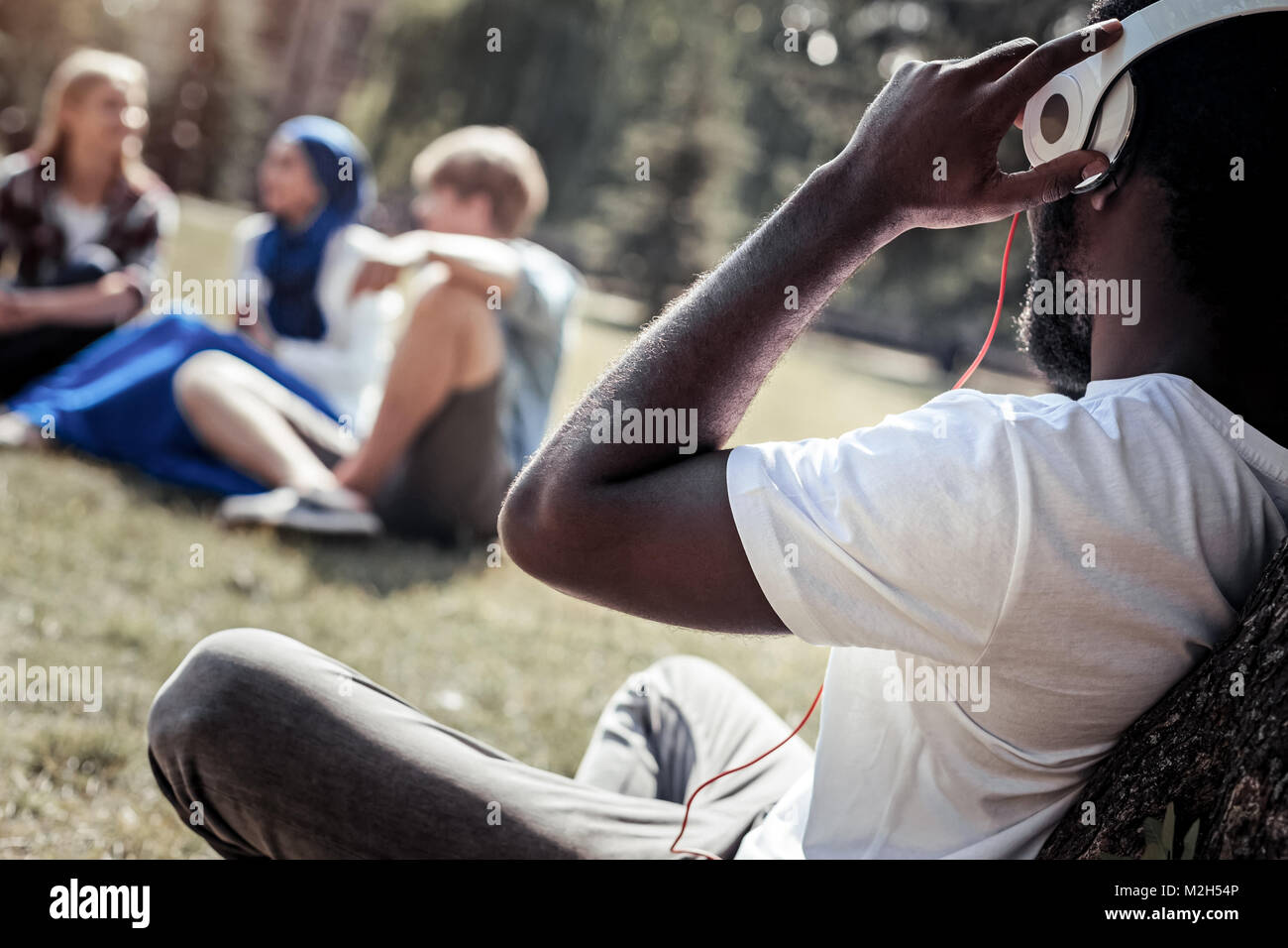 Felice l'uomo rilassato tenendo le sue cuffie Foto Stock