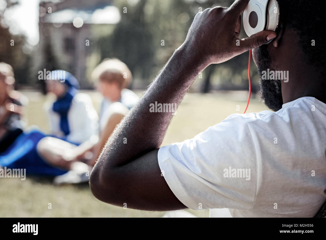 Positivo giovane messa sulle cuffie Foto Stock