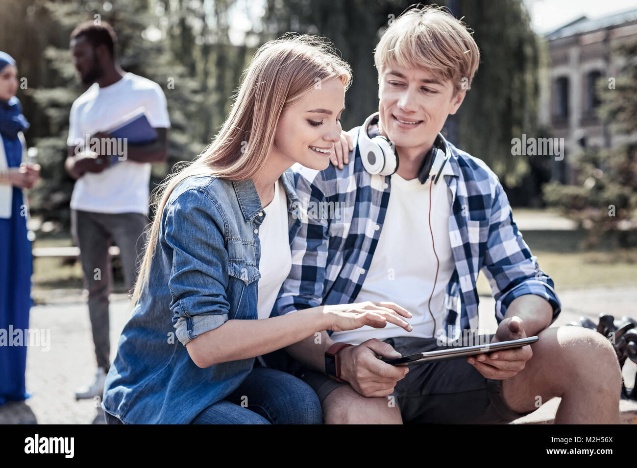 Felice giovane donna che mantiene i suoi amici a spallamenti Foto Stock