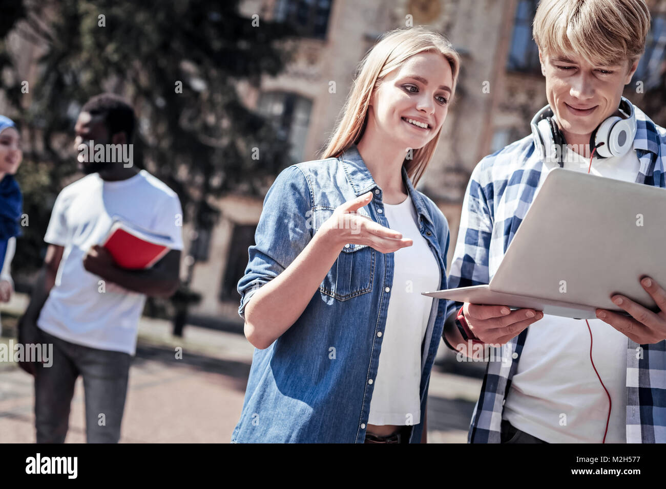 Allegro piacevole donna puntando al laptop Foto Stock