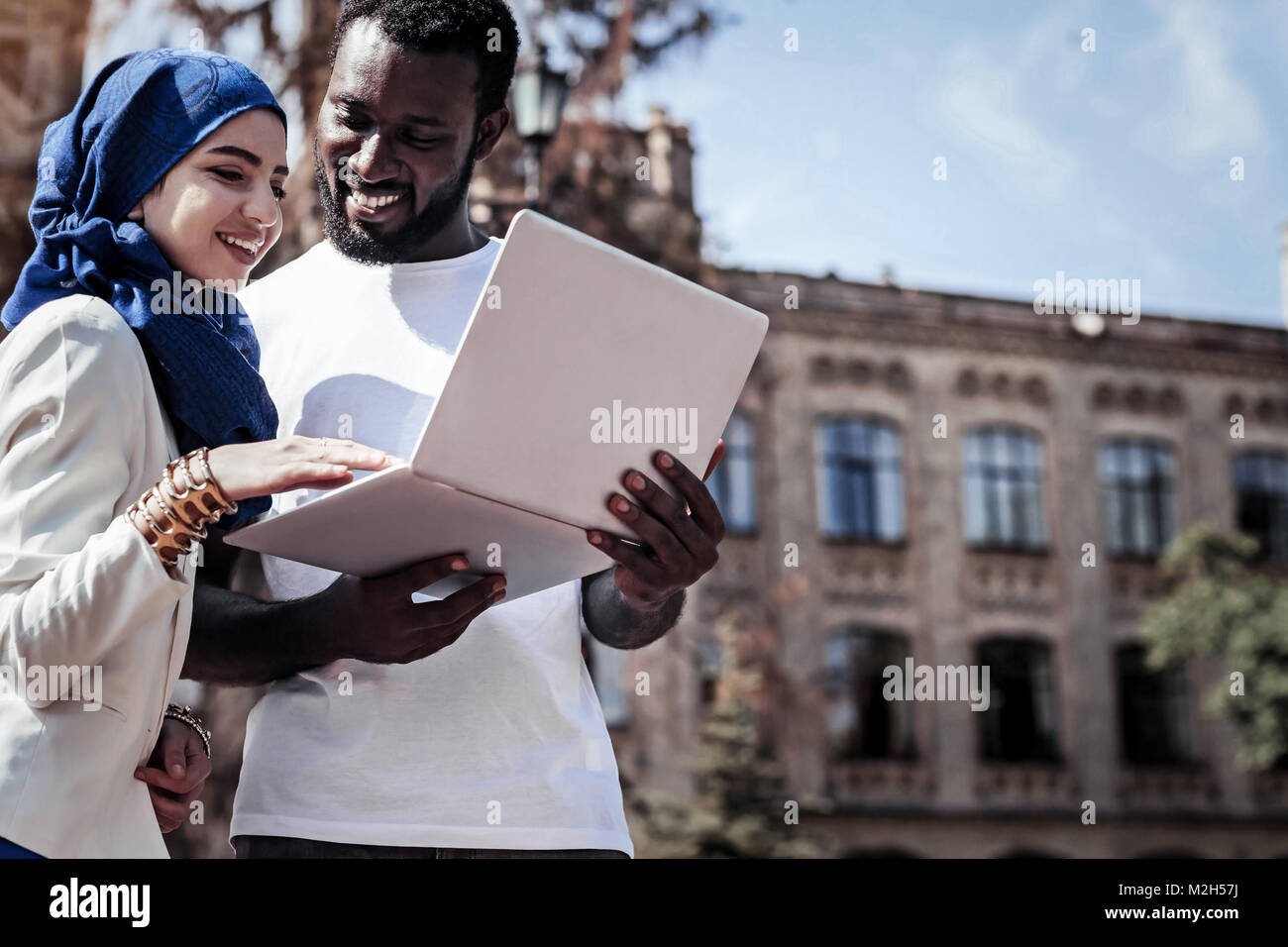 Lieto uomo bello che mantiene un notebook Foto Stock