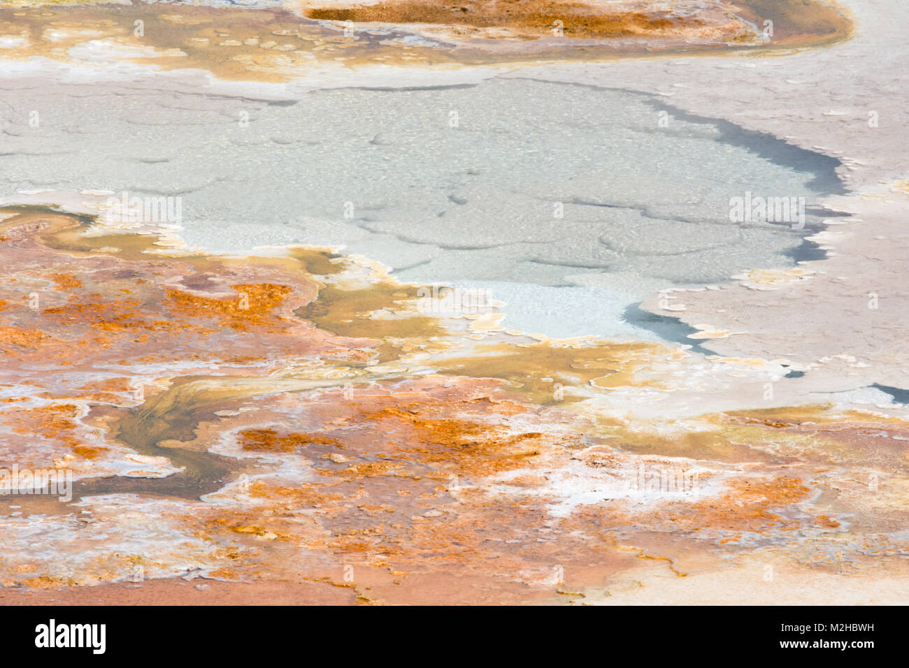 Un flusso di acqua precipita su suolo arancione e in un colore biancastro blu piscina di acqua. Foto Stock