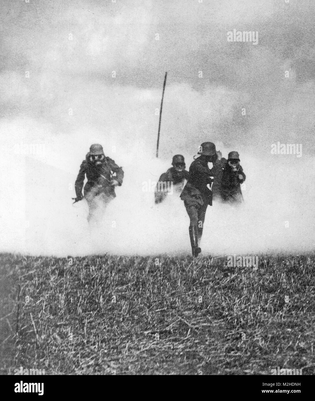Prima guerra mondiale i soldati tedeschi pratica avanzando con maschere attraverso una nube di gas. Il polo segna il loro punto di partenza. Foto Stock