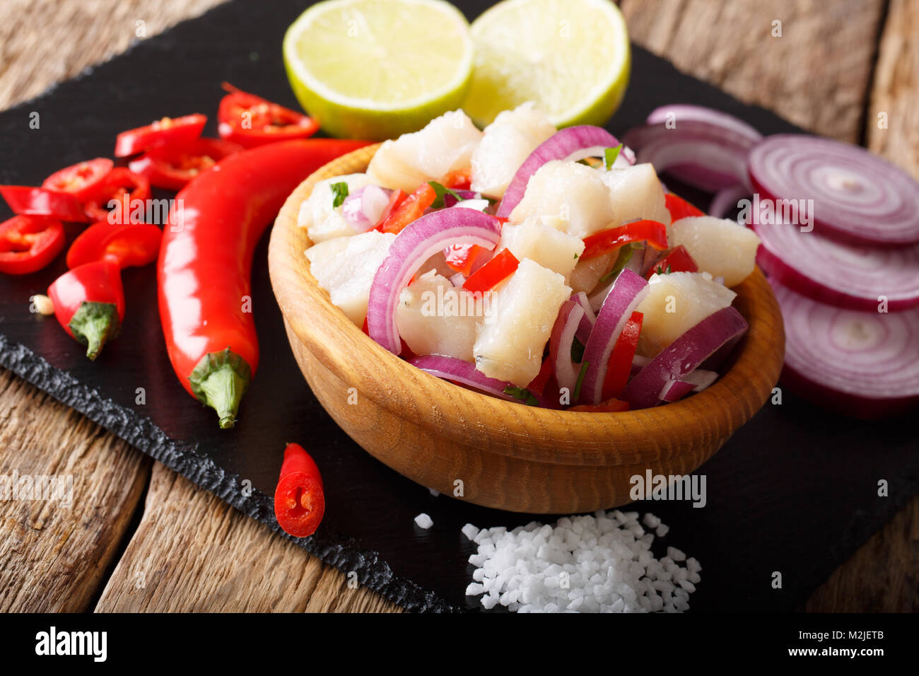 Snack ceviche di pesce bianco con cipolla e pepe vicino fino in una ciotola sul tavolo orizzontale. Foto Stock