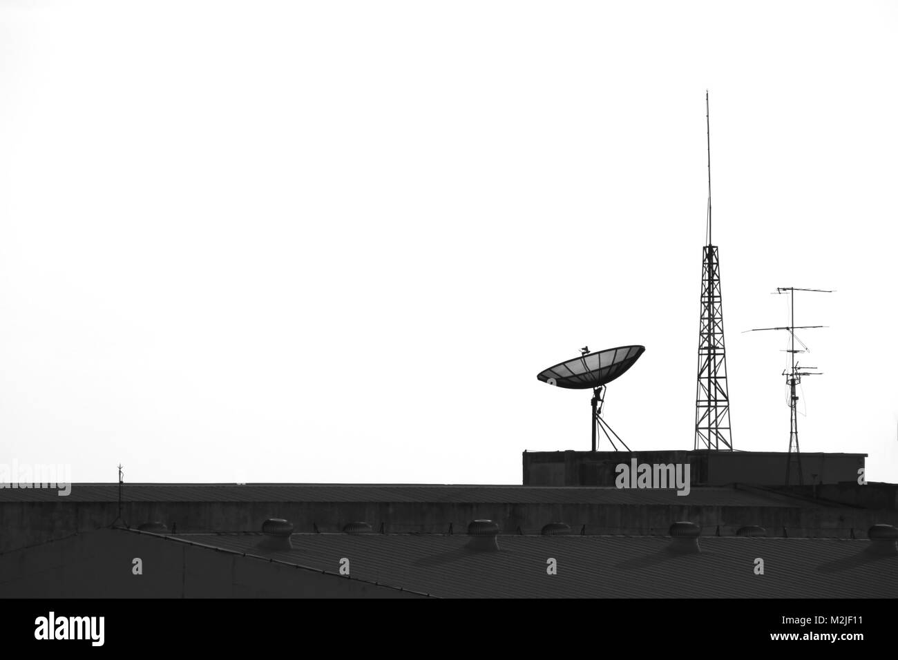 Tv satellitare e antenna sulla parte superiore della fabbrica Foto Stock
