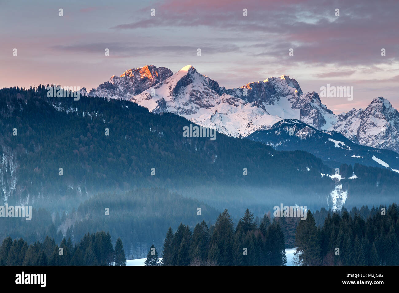 Alpenglow, montagne del Wetterstein, con Zugspitze, in inverno Foto Stock