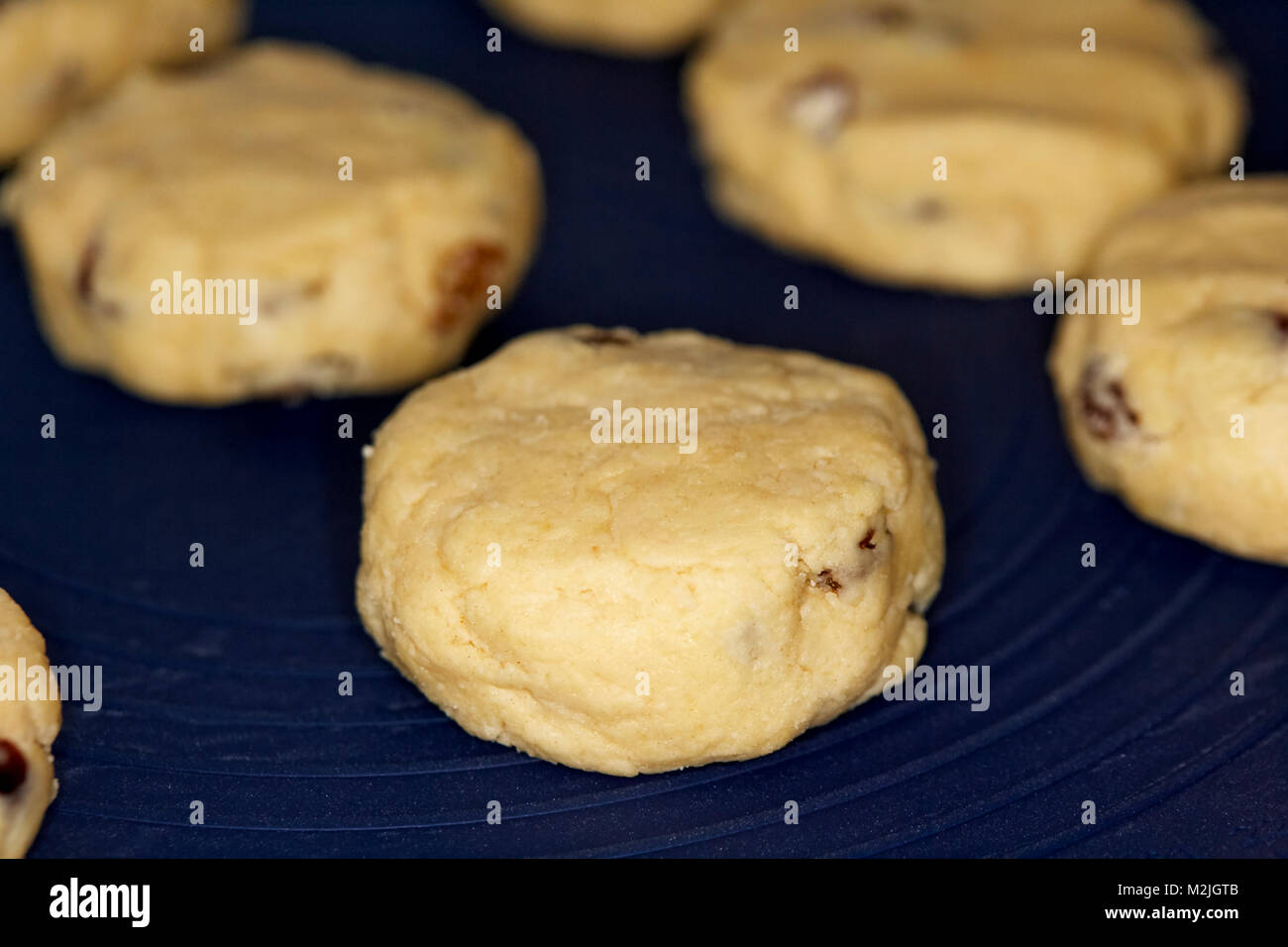 Fatto in casa focaccine di frutta nota come torte di roccia su un silicone Tappeto di cottura pronta per andare in forno Foto Stock