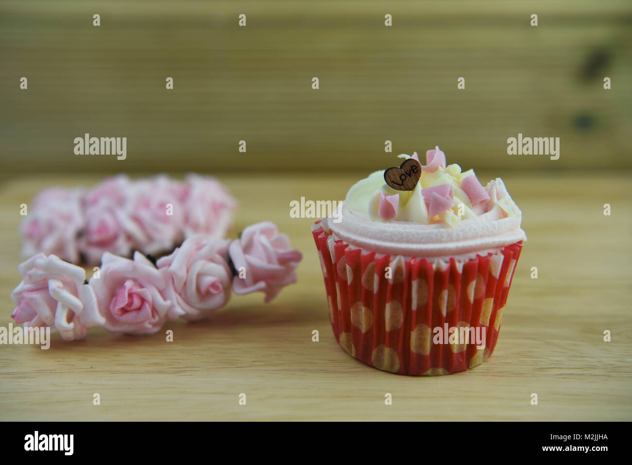 Romantica coppa artigianali torte con rosa e bianco ghiaccio e riccioli di cioccolato con rosa miniatura carta rose e amore forme di cuore Foto Stock