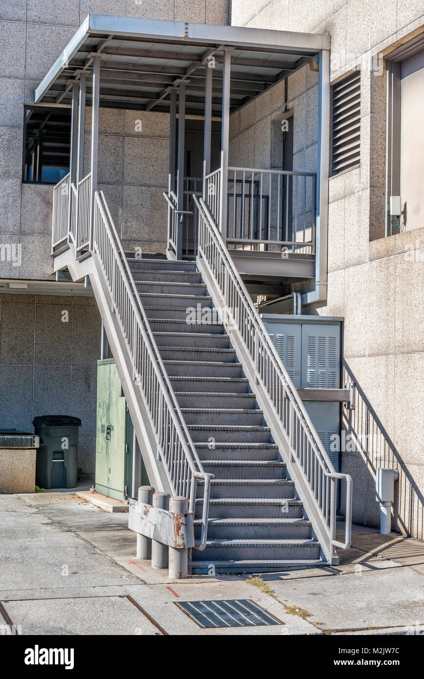 Colpo verticale di una scala metallica dietro un edificio industriale. Foto Stock