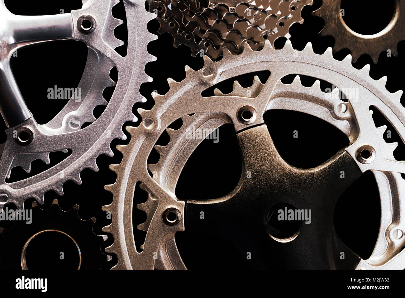 Close-up di vari tipi di ingranaggi di bicicletta su sfondo nero Foto Stock