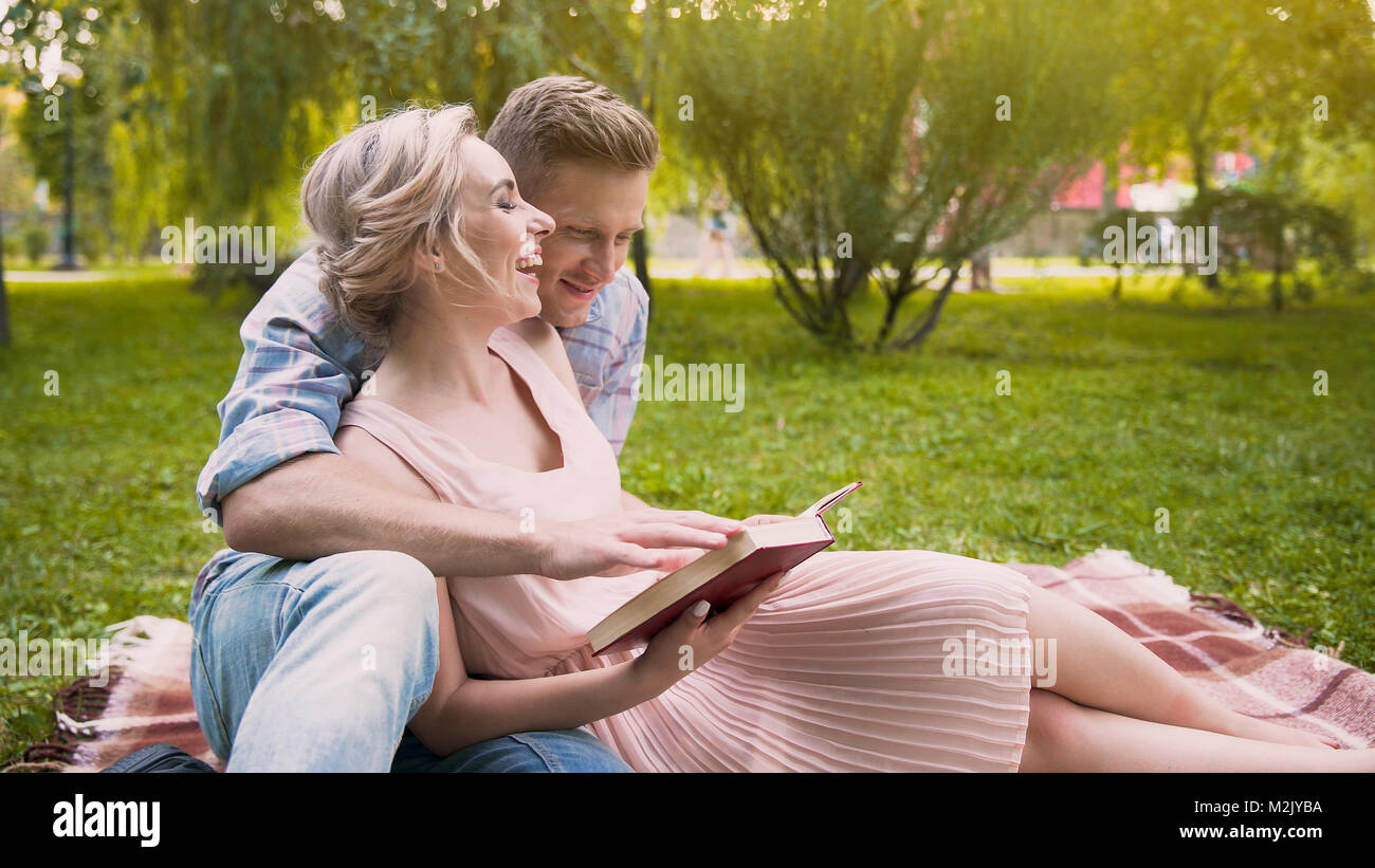 Allegro giovane godendo il tempo libero nel parco libro di lettura e divertirsi insieme Foto Stock