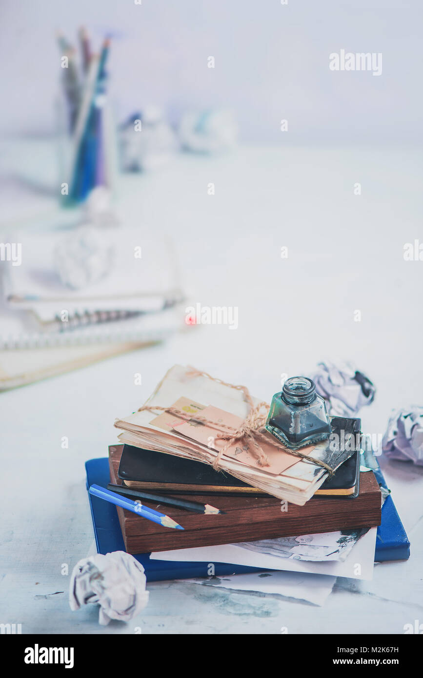 Copyriter workplace con un inkwell su una pila di bozze, astucci per matite e carte. Elevato La chiave ancora in vita. Scrittura creativa concetto con copia spazio. Foto Stock