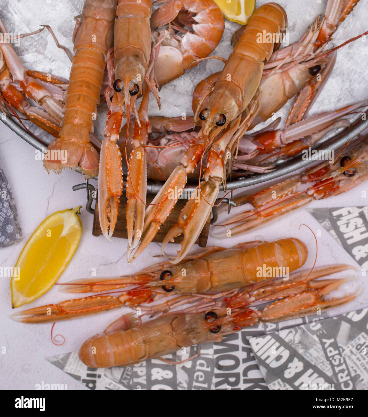 Langoustine cotti con il limone in un vassoio Foto Stock