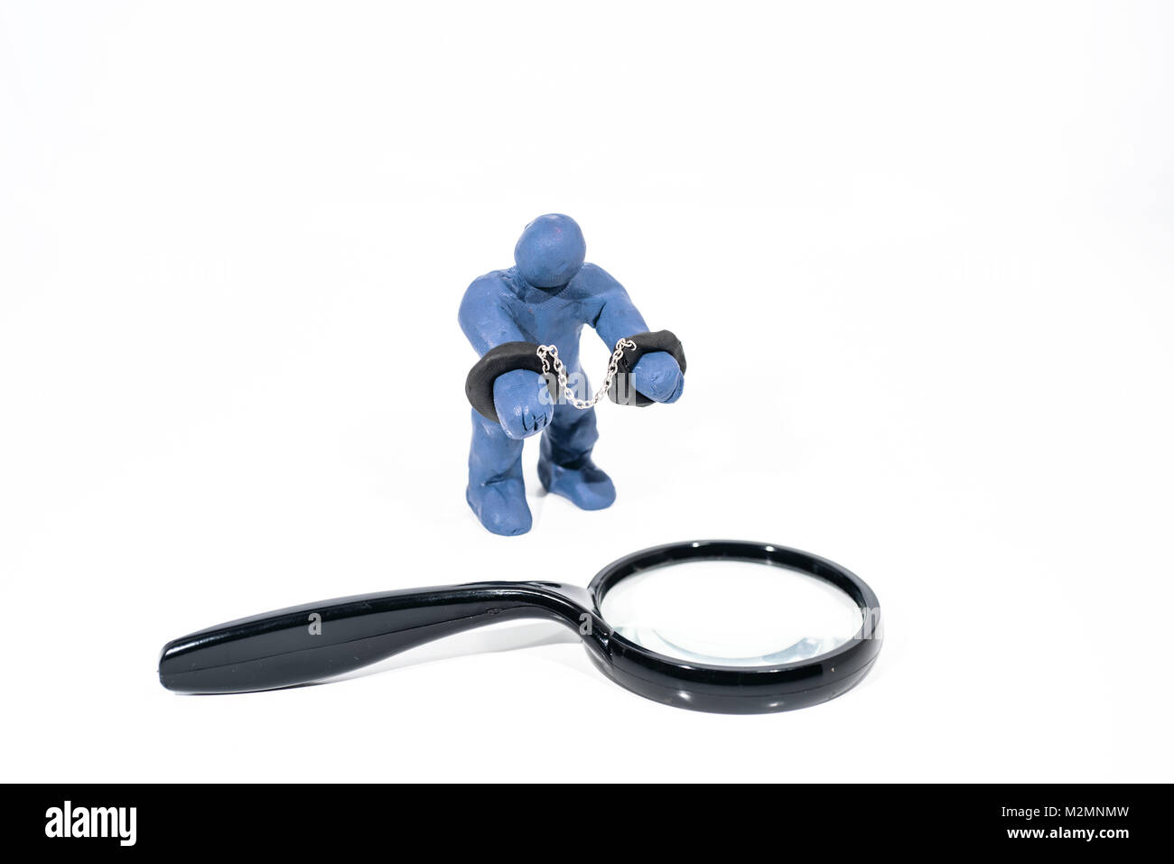 Piccolo Blu figura in manette. Realizzato dal gioco in argilla. Isolato su sfondo bianco. Foto Stock