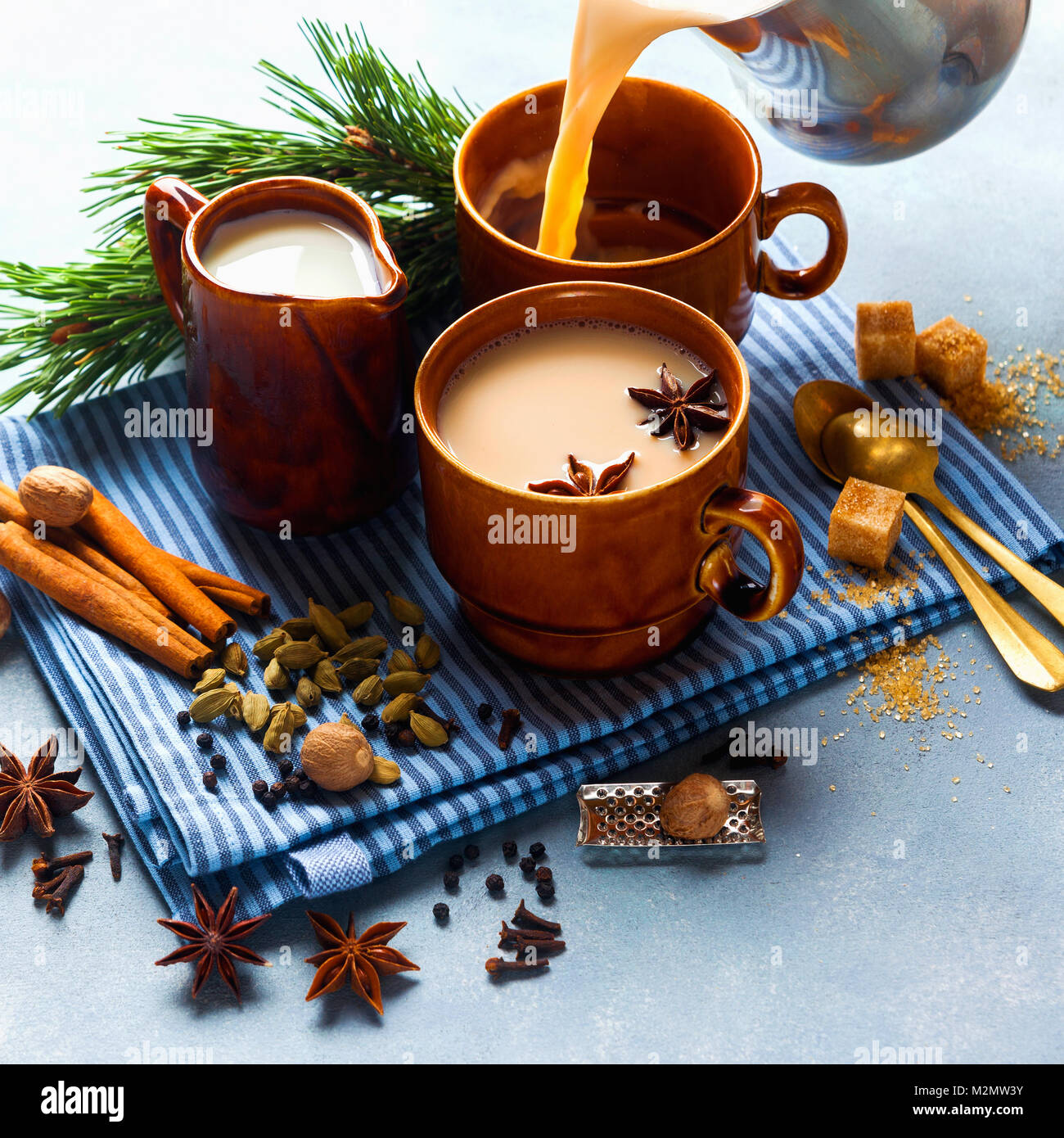 Versando Masala tea chai latte caldo tradizionale indiano cerimonia del tè del latte dolce con spezie, erbe organico sano di infusione bevanda in tazza di porcellana Foto Stock