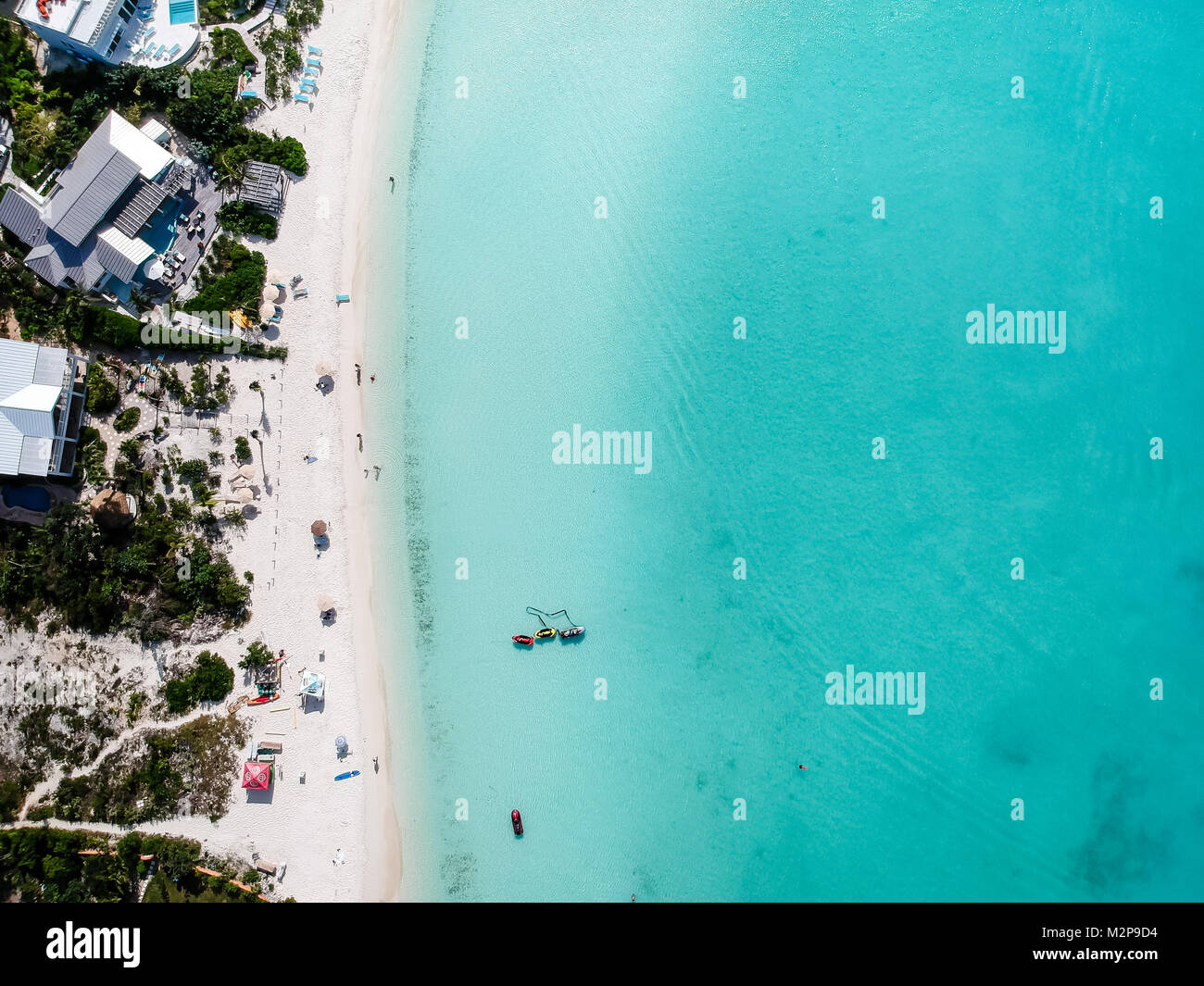 Drone foto della spiaggia di Grace Bay, Providenciales, Turks e Caicos. Caraibi il mare blu e rocce sottomarine può essere visto, così come alcuni jet skie Foto Stock