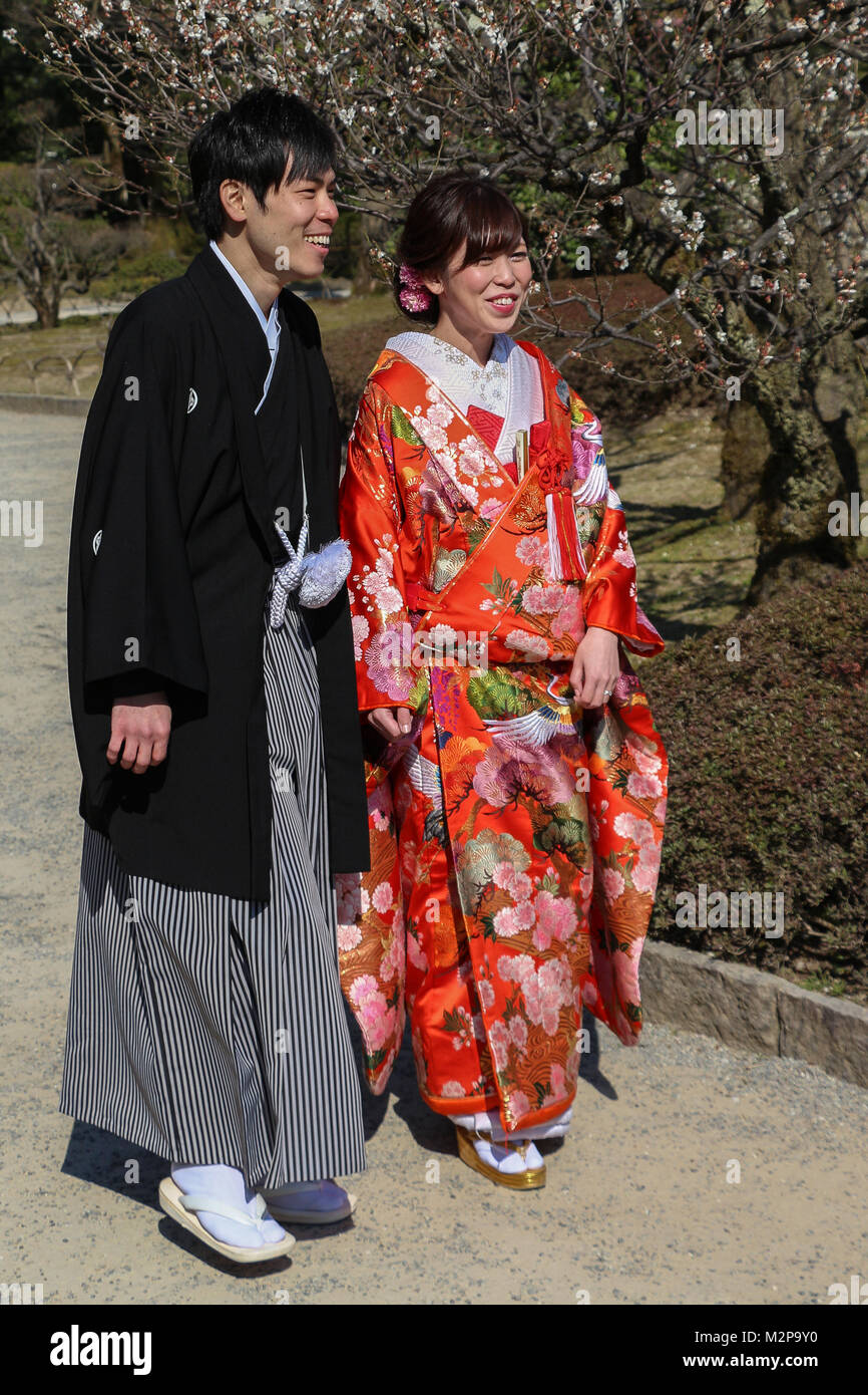Kanazawa, Giappone - una giovane coppia celebra il loro primo anno di matrimonio avendo il loro ritratto preso nel giardino Kenrokuen in kimono di nozze. Foto Stock
