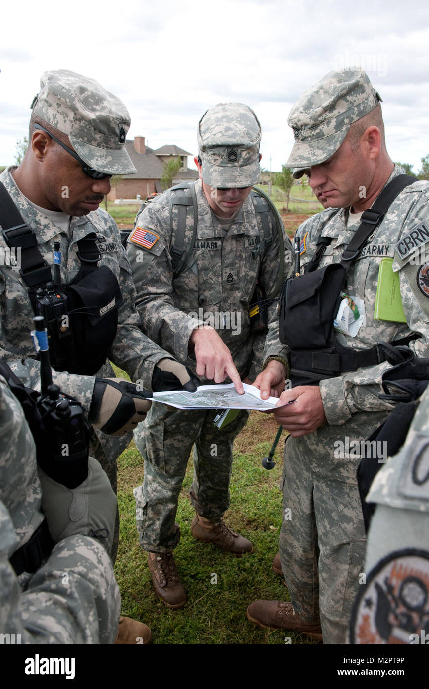 Sgt. 1. Classe Lawrence Jarrett (sinistra), di Spencer, Okla., Sgt. 1. Classe Jared Hallmark (centro), di Guerre Indiane, Okla., e Master Sgt. Ken Perry (a destra), di Shawnee, Okla., esaminare una mappa dell'area in cui essi sono circa per la ricerca per la mancanza di un bambino di tre anni ragazzo. Tutti e tre sono membri della 63a sostegno civile Team (CST), Oklahoma Guardia Nazionale. Il ragazzo mancante è stato tirato dalla sua casa da un tornado il 24 maggio. Foto: CPT Geoff Legler, Oklahoma 63CST Piemonte Tornado 007 da Oklahoma Guardia Nazionale Foto Stock