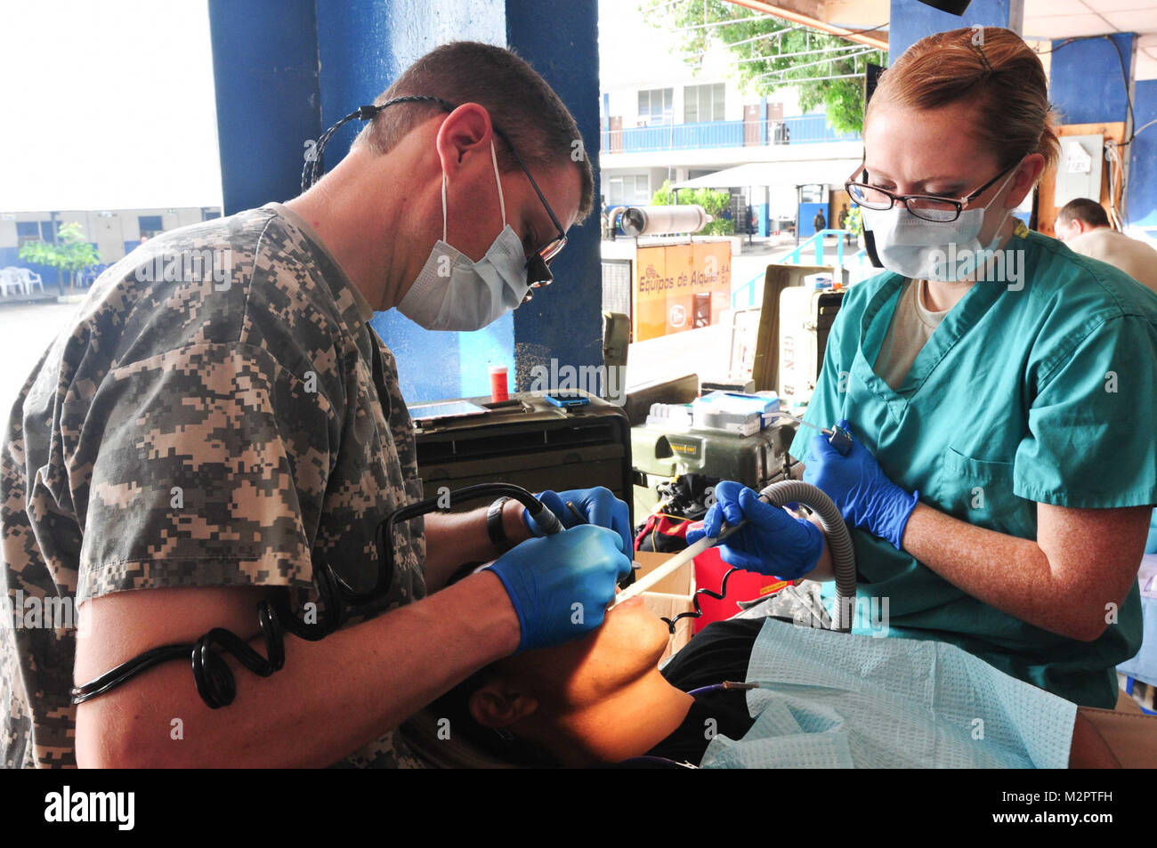 Il Mag. Mike Crowton e SPC. Megan Kelley del 143Società dentale mettere un riempimento in su un vescovo salvadoregno di dente all'U.S. dental clinic in San Vicente. (Foto di magg. Matt Lawrence, 807th MDSC Affari pubblici) 20110531-DSC 5298-2 da 807MCDS Foto Stock