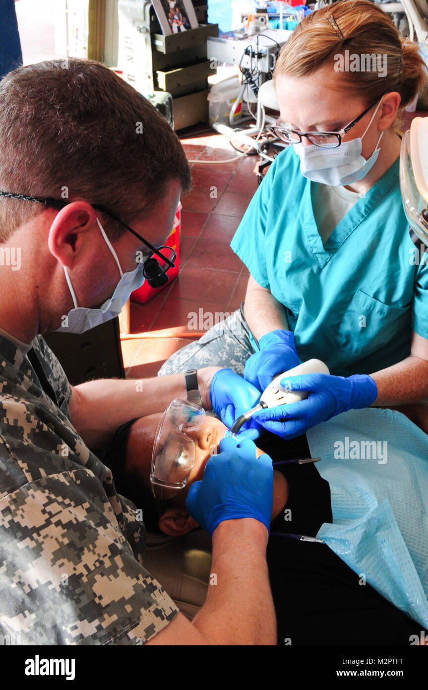 Il Mag. Mike Crowton e SPC. Megan Kelley del 143Società dentale indurire un riempimento in un vescovo salvadoregno di dente all'U.S. dental clinic in San Vicente il 31 maggio 2011. La clinica DEGLI STATI UNITI trattati oltre 1.000 pazienti e ha dato fluouride per oltre 500 bambini della scuola nei dieci giorni di missione. (Foto di magg. Matt Lawrence, 807th MDSC Affari pubblici) 20110531-DSC 5334-7 da 807MCDS Foto Stock