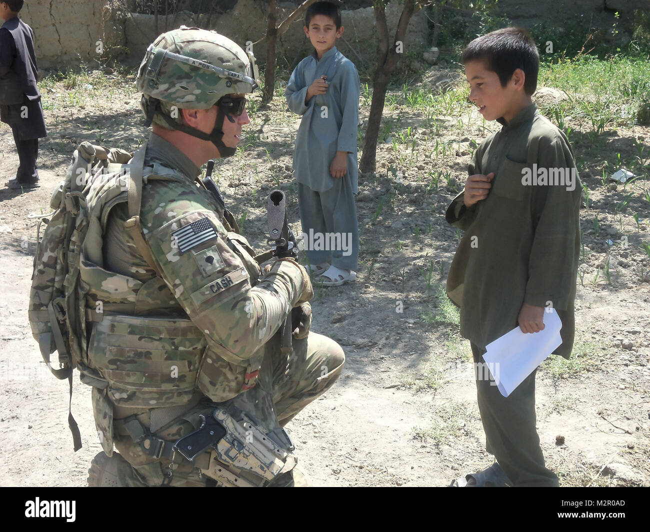 Stati Uniti Army Spc. Justin in contanti, una forza di sicurezza soldato con la Georgia agro-alimentare del team di sviluppo, da Acworth, Ga., pause per comunicare con un ragazzo afgano durante una pattuglia nel distretto di Koshi luglio 7. La Georgia ADT in Afghanistan da parte della Georgia di guardia nazionale Foto Stock