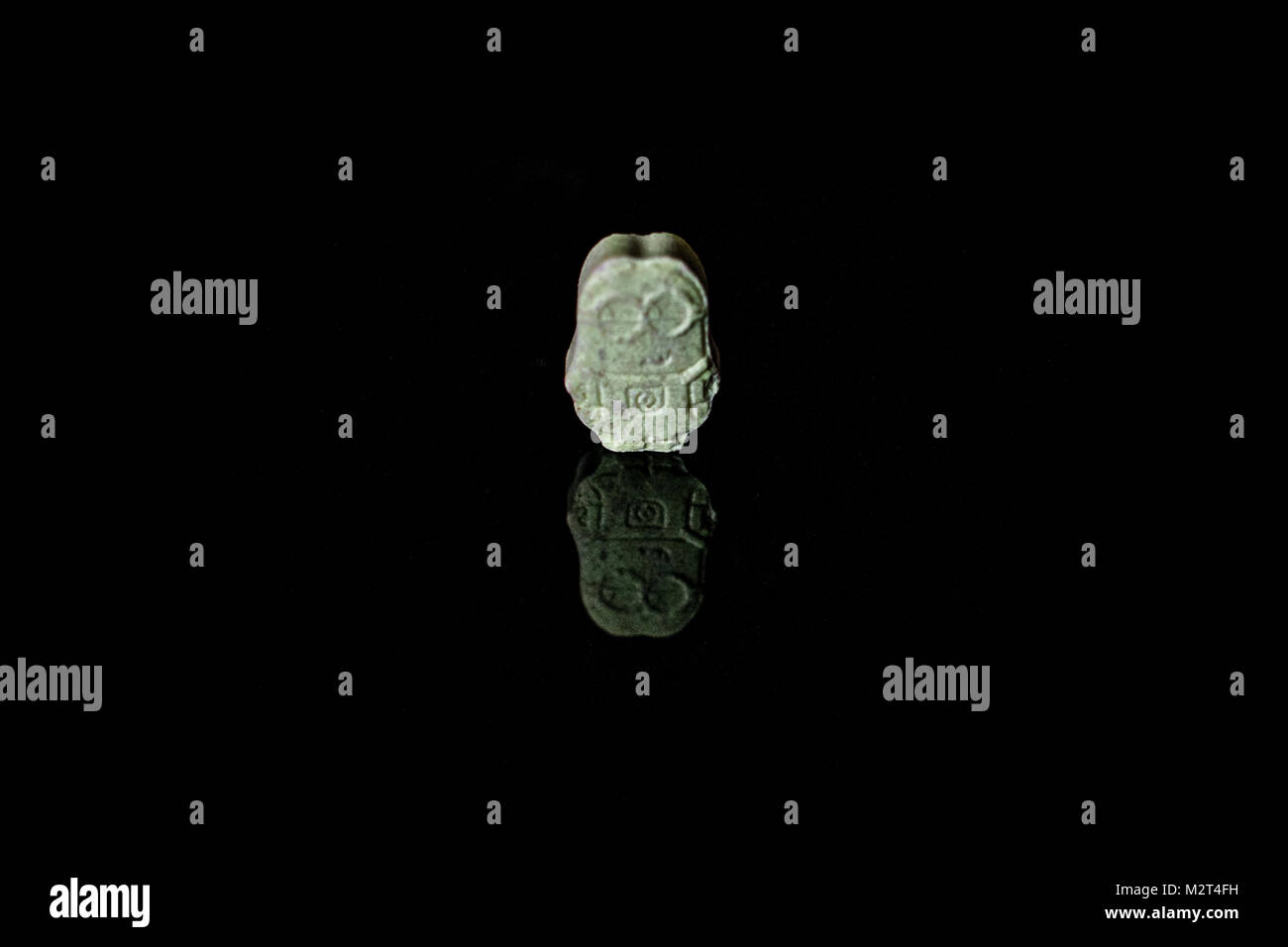 Herefordshire, Regno Unito. 8 febbraio, 2018. Un sistema illegale di pasticca di ecstasy che è stata premuta nella forma di un carattere Minion (giallo fictional creature che appaiono nell'spregevole Me movie franchising), visto su un tavolo il 8 febbraio 2017. Noto come MDMA o "E", Ecstasy è una droga illegale che induce sensazioni di euforia e di energia e benessere. La ricerca suggerisce che l'ecstasy è una neurotossina. Molti decessi correlati all'ecstasy si sono verificati, principalmente a causa di disidratazione. Credito: Jim legno/Alamy Live News Foto Stock