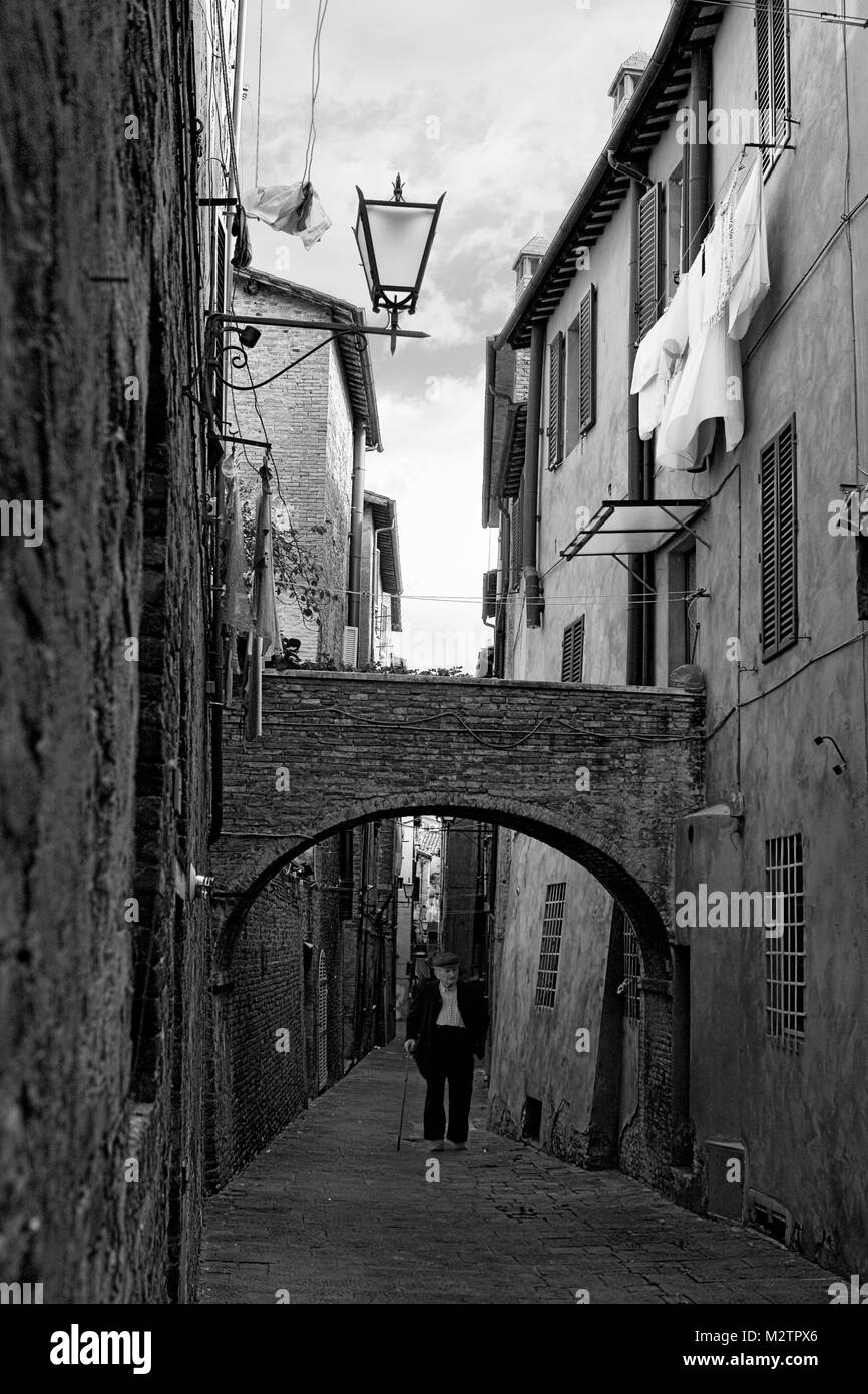 Vicolo della Tartuca, un medievale vicolo cieco con un flying bridge, in Contrada della Tartuca a Siena, Toscana, Italia: versione monocromatica Foto Stock