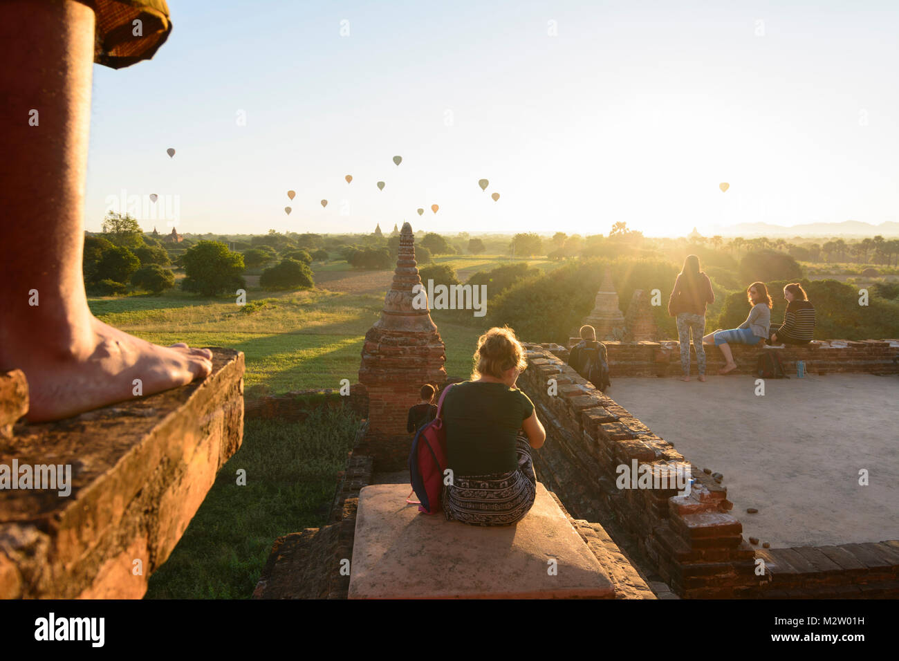 Bagan: vista dal tempio Taung Guni Paya, gamba di monaco, turisti guarda sunrise, templi, gli stupa, palloncini, , Mandalay Regione, Myanmar (Birmania) Foto Stock