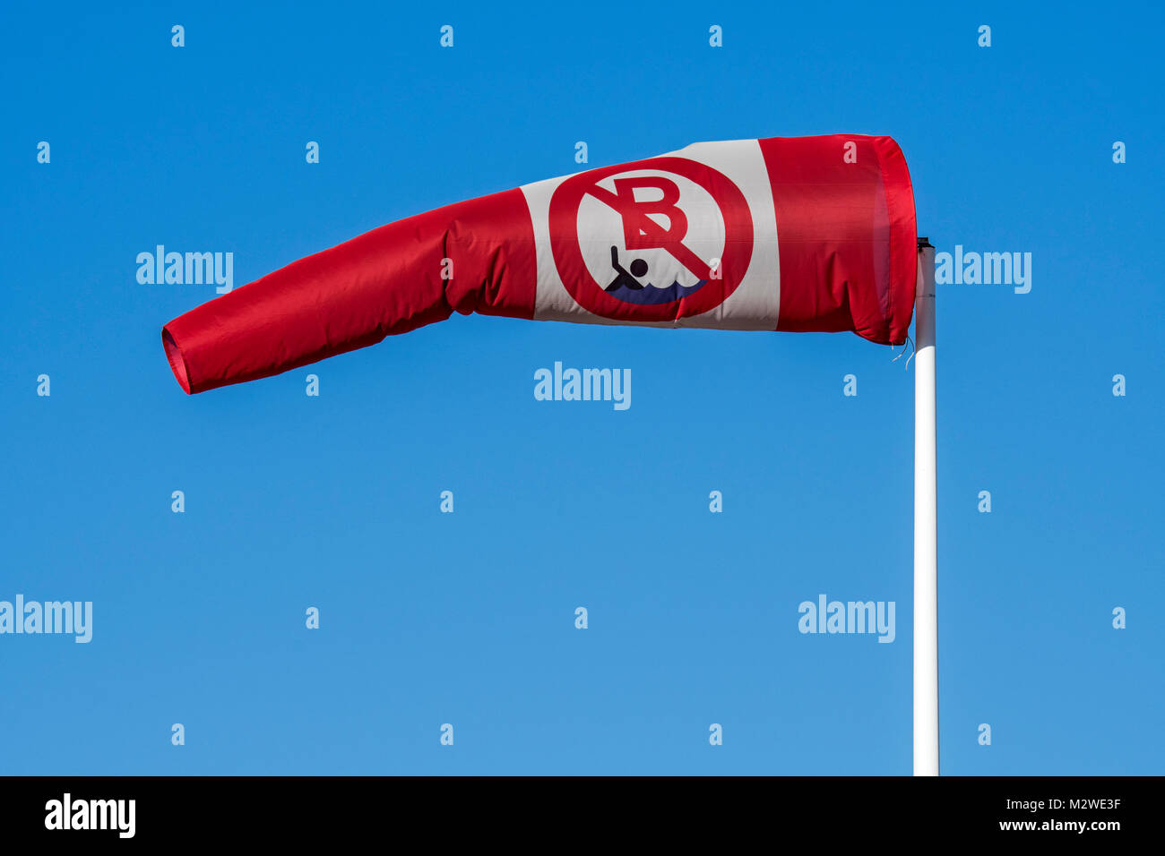 Soffiaggio di rosso e bianco con manica a vento n. nuoto / nessun avviso di balneazione che mostra direzione e velocità del vento Foto Stock