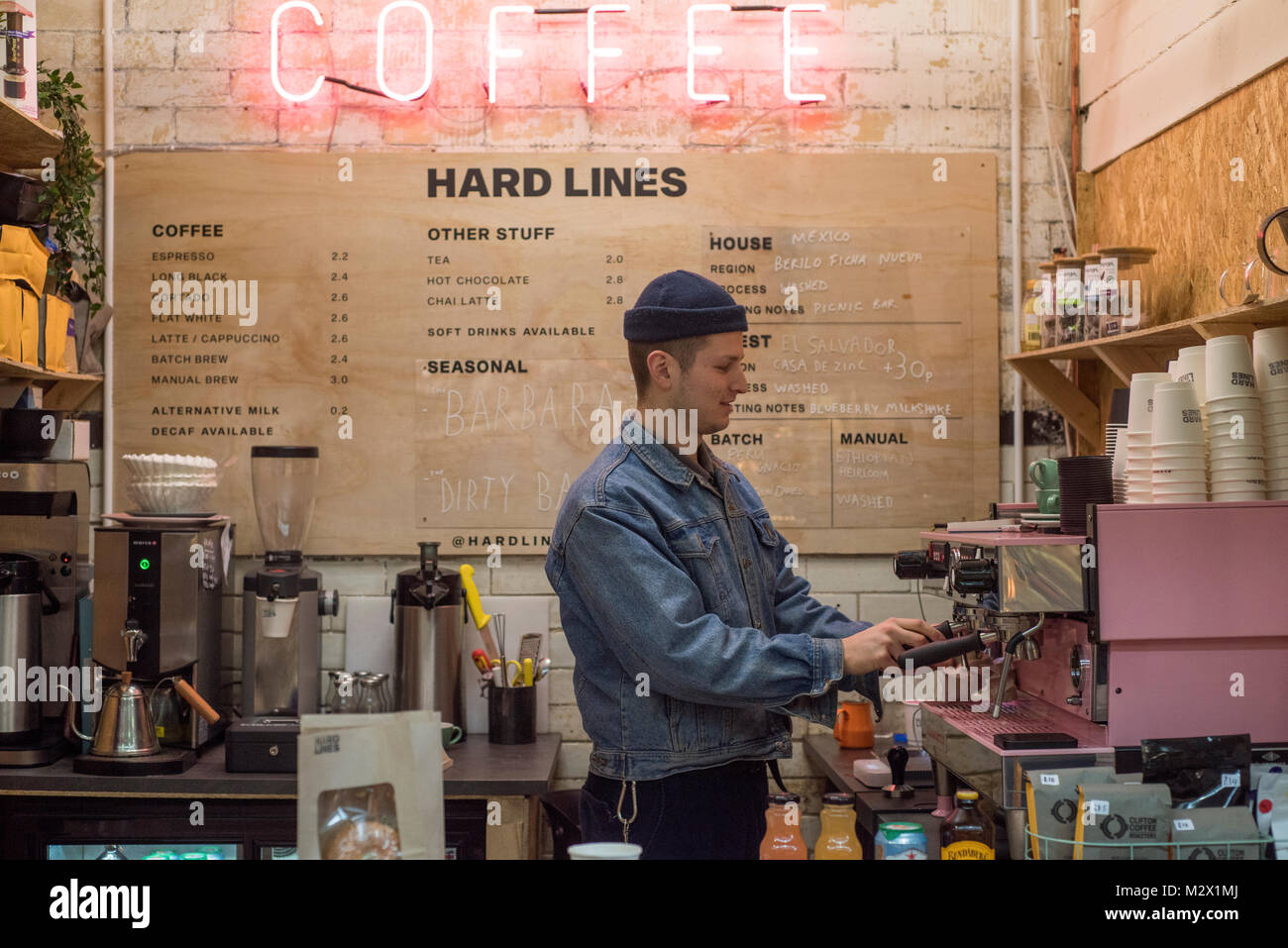 Mercato di Cardiff, Cardiff, Galles, UK. 8 febbraio 2018. Zak Thomas, 22, pulisce la macchina del caffè a tubi rigidi. Questo è il secondo ramo di questo piccole Foto Stock