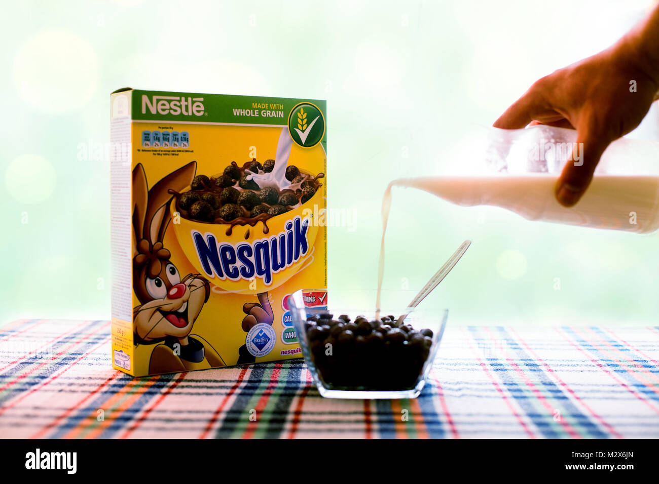 SOFIA , BULGAIRA Aprile 29, 2015: box Nesquick mattina cereale e mano umana con il latte. Nesquick è realizzato da Nestlé la più grande azienda alimentare nel wor Foto Stock