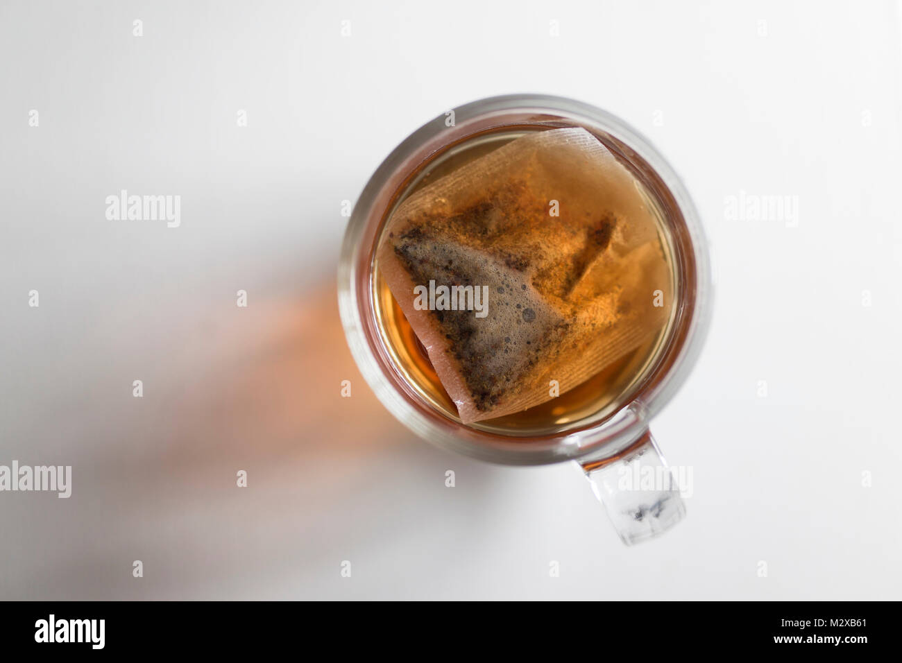 Vista dall'alto in basso di tè in una tazza di vetro su sfondo bianco Foto Stock