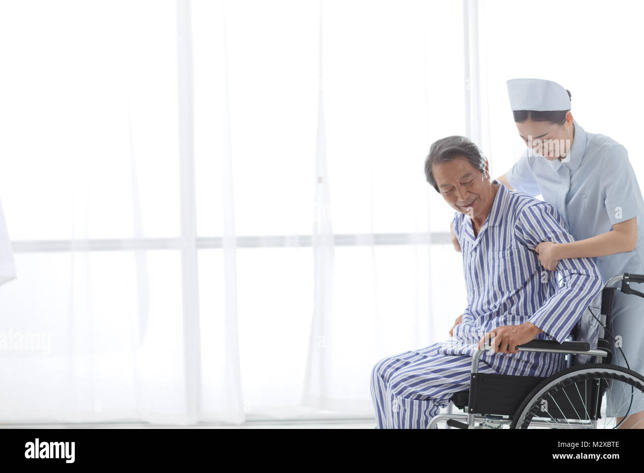 L'infermiere per assistere il paziente la formazione di riabilitazione Foto Stock