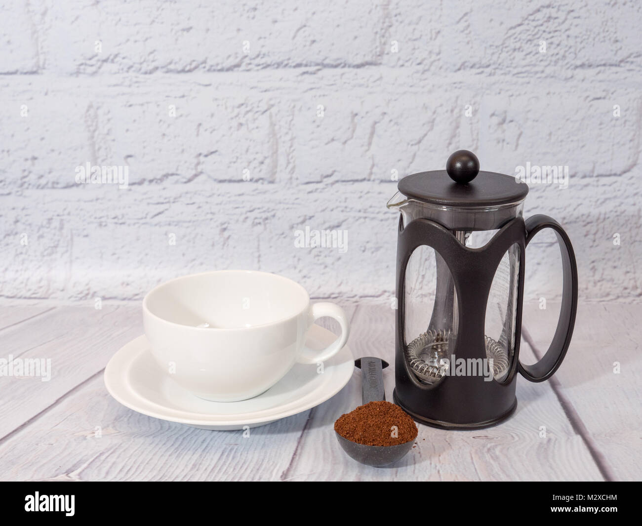 Bianco una tazza di caffè con un cafetiere e una misura di caffè macinato Foto Stock