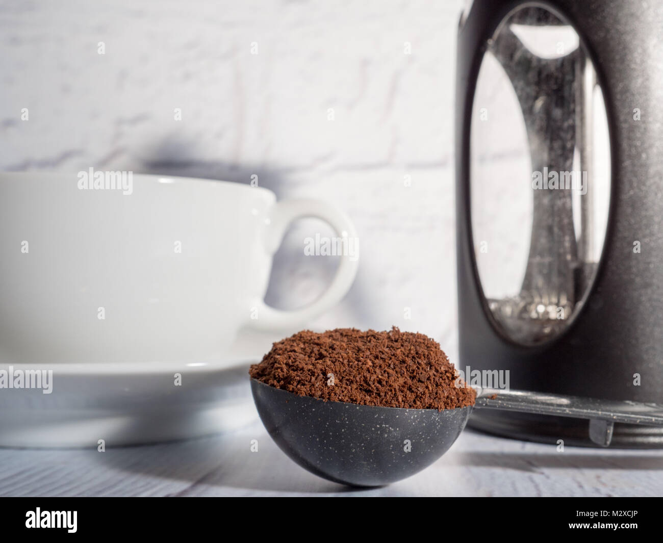 Bianco una tazza di caffè con un cafetiere e una misura di caffè macinato Foto Stock