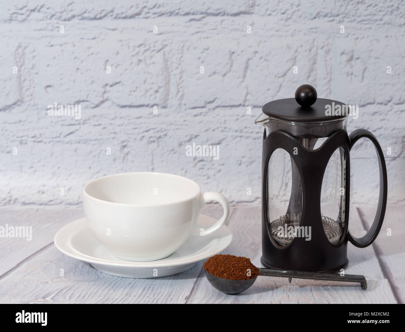 Bianco una tazza di caffè con un cafetiere e una misura di caffè macinato Foto Stock