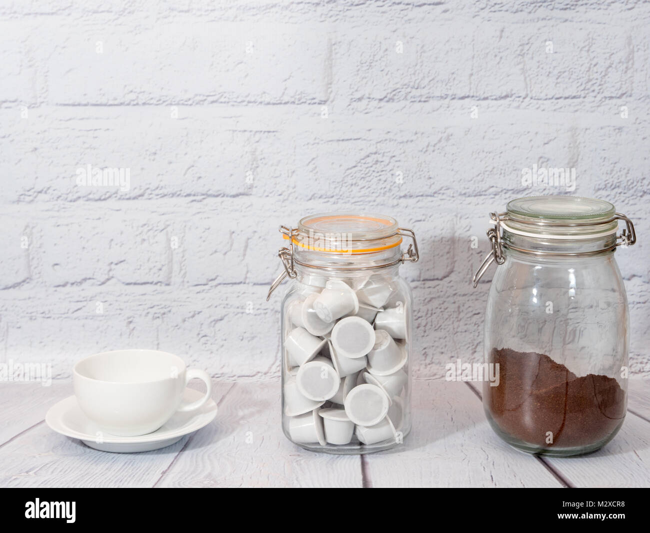 Bianco una tazza di caffè con un barattolo di caffè macinato e bianco generico nespresso montare le cialde di caffè Foto Stock