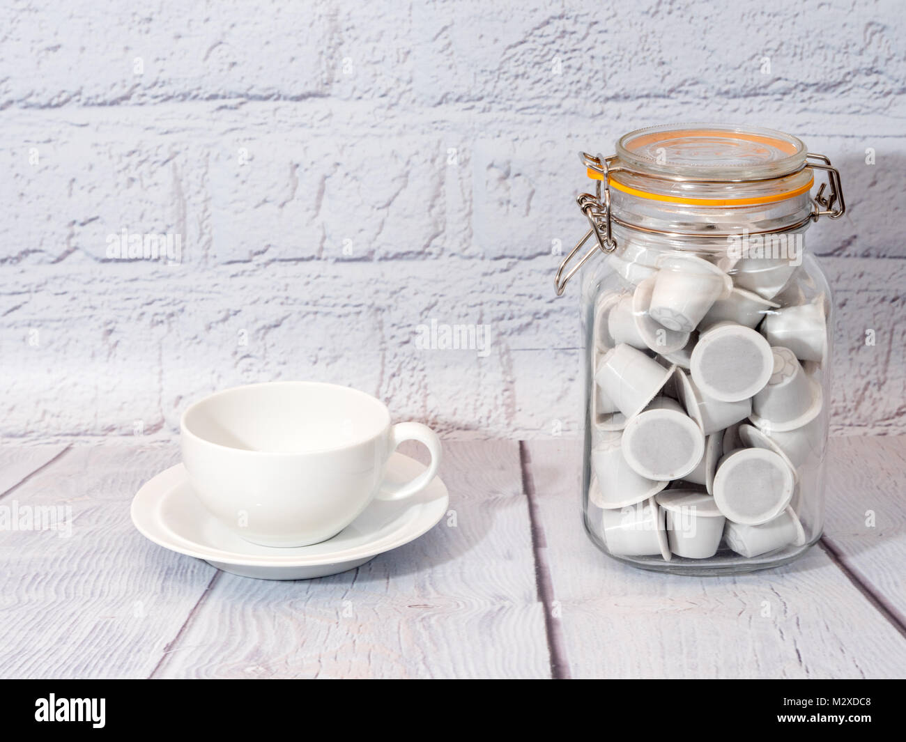 Un bianco tazza da caffè con bianco generico nespresso montare le cialde di caffè Foto Stock
