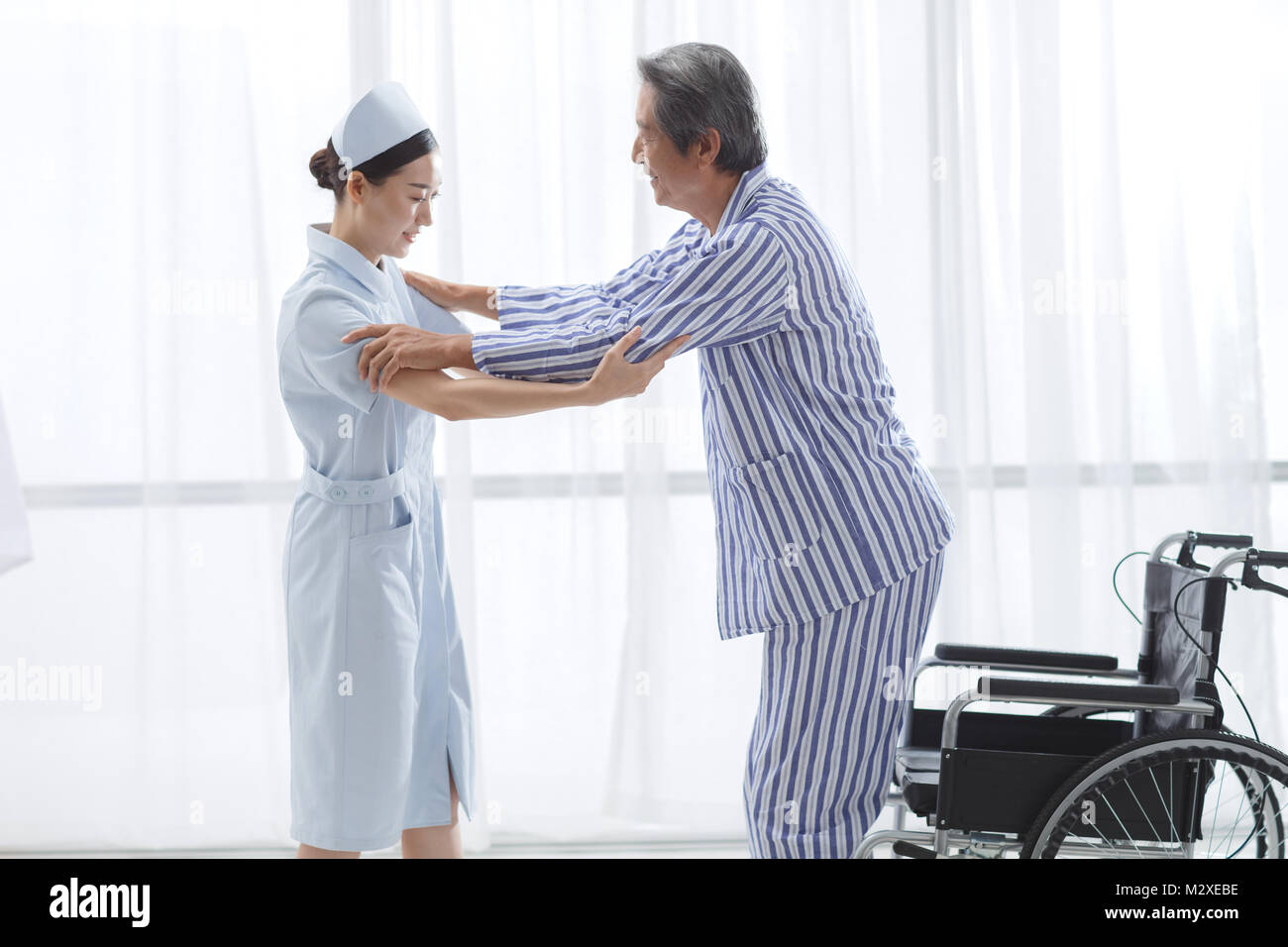 L'infermiere per assistere il paziente la formazione di riabilitazione Foto Stock