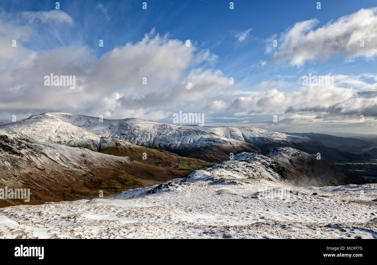 Guardando verso il basso oltre la cresta di Gibson Knott e timone roccioso con il Fairfield Horseshoe nella distanza su un freddo inverno fresco del giorno Foto Stock