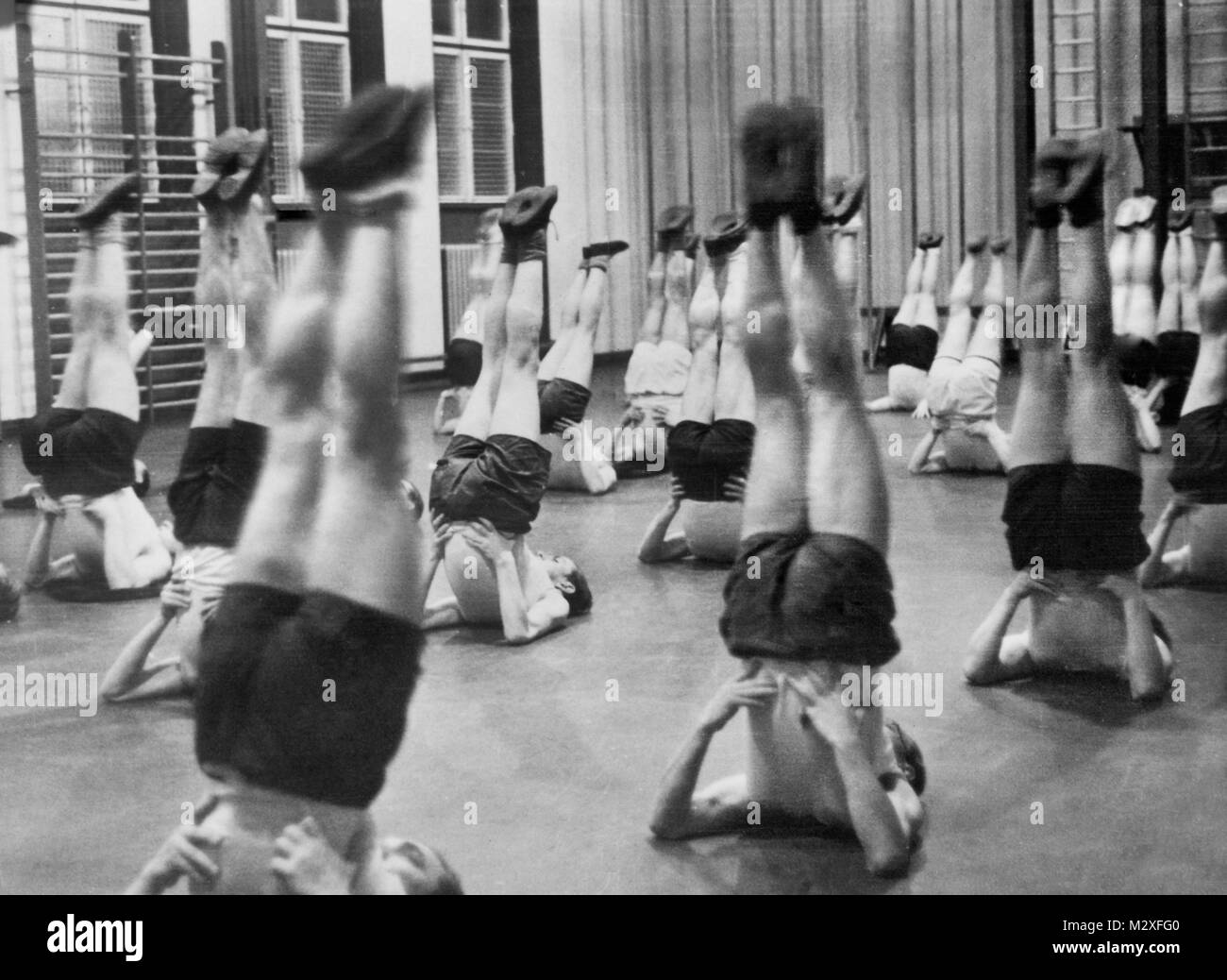 Sottosopra di uomini in palestra classe, ca. 1935. Foto Stock