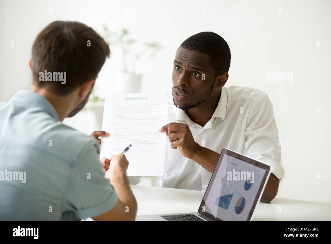 Scontento arrabbiato imprenditore africana sostenendo in disaccordo circa il contratto di business prestito frode, insoddisfatto investitore nero avente controversia con il bianco pa Foto Stock