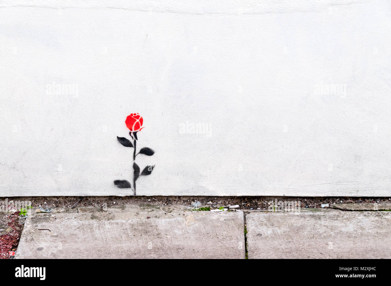 Una sola rosa rossa dipinta su un muro di Greenwich, Londra del sud Foto Stock