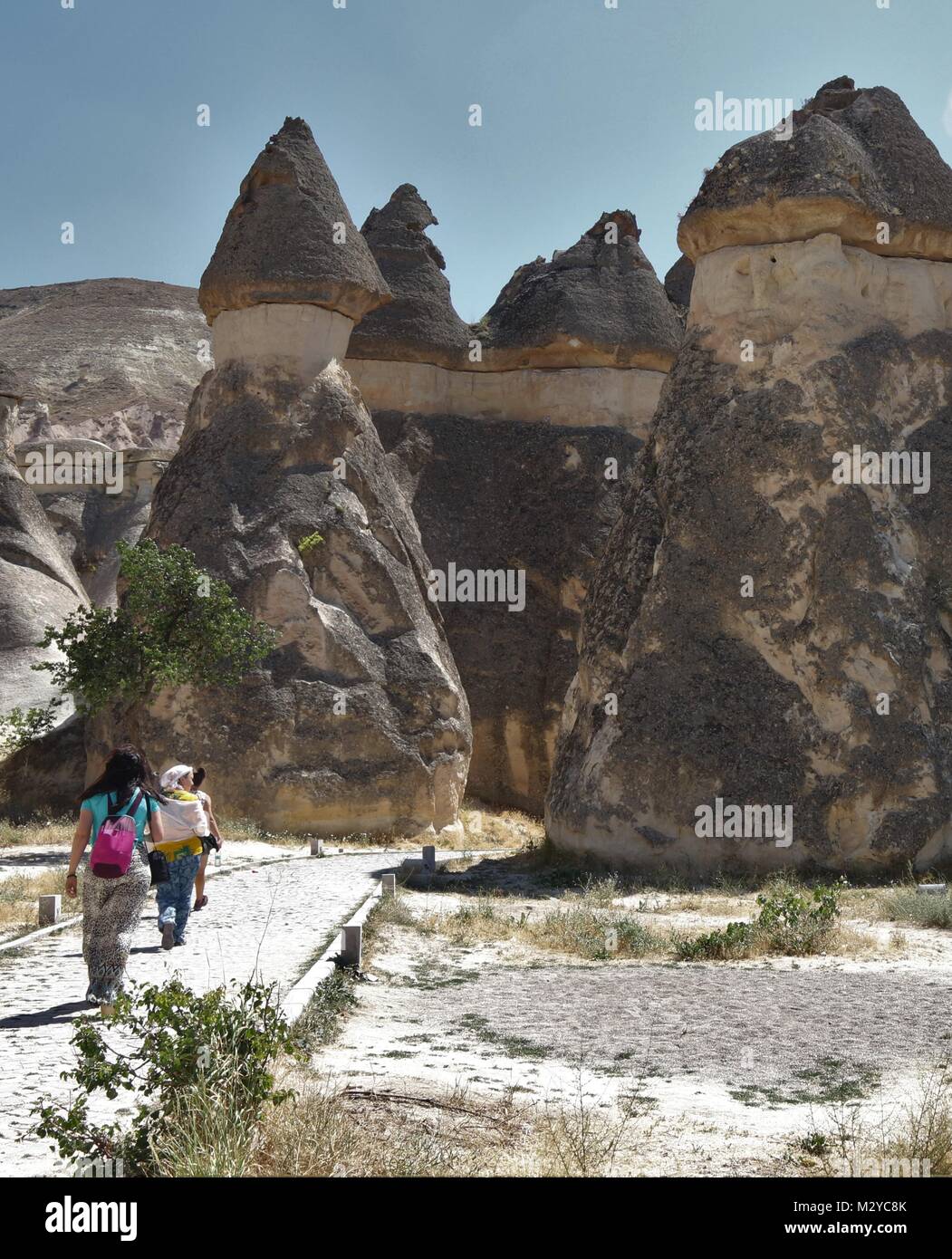 I turisti che visitano alcuni dei famosi Camini di Fata in Cappadocia che furono scavate dal popolo per essere utilizzati come case e chiese in Turchia Foto Stock